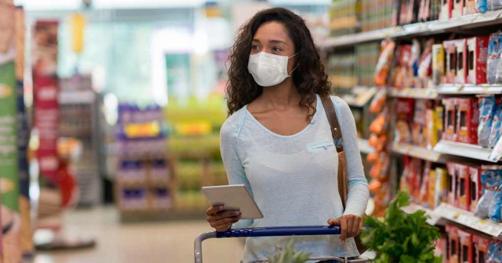 Picture of woman shopping at the supermarket wearing a facemask