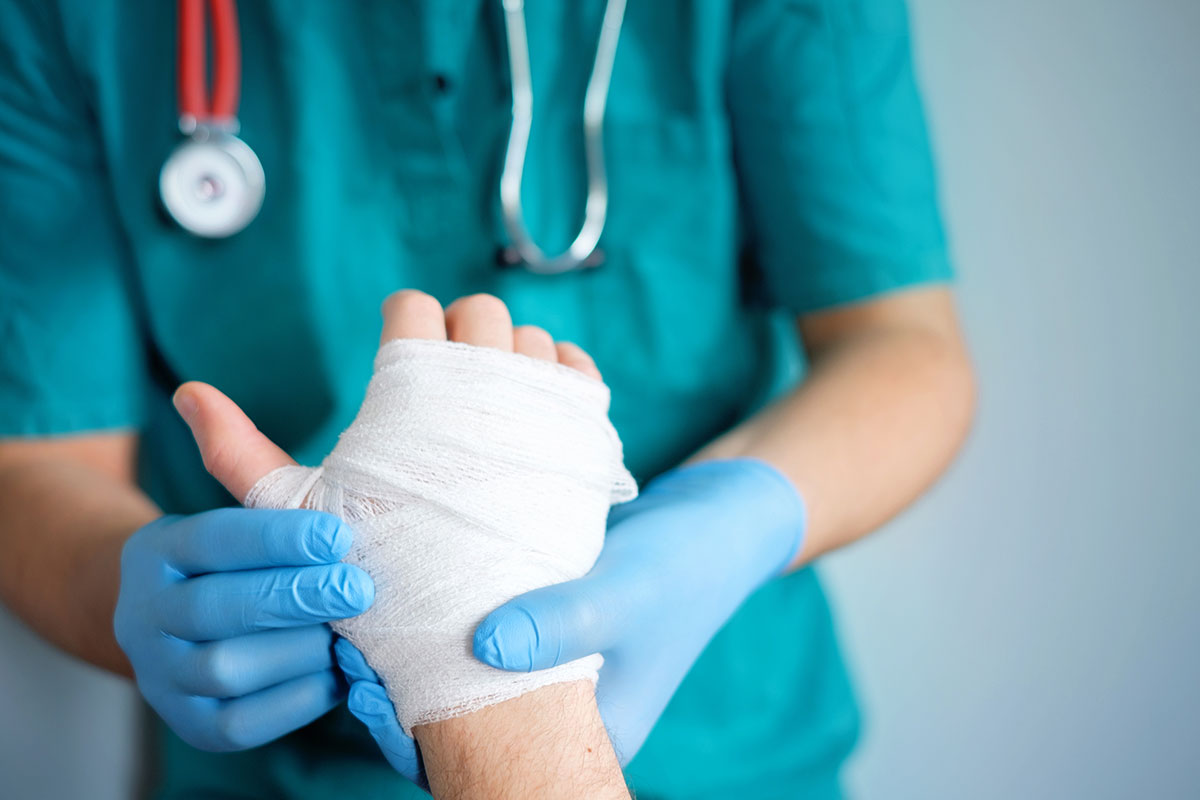 doctor wrapping a patients hand in a bandage